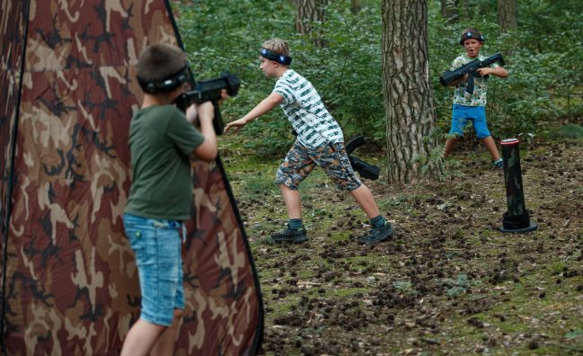 dzieci grające w paintball laserowy w parku podczas organizowanego eventu z okazji dnia dziecka